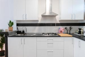 a kitchen with white cabinets and a sink at Satu Granada Modern Apartment in the Albaicín in Granada