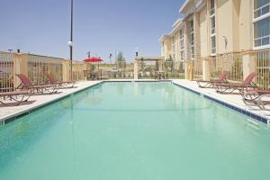 una piscina con sillas y agua azul en La Quinta by Wyndham Dallas I-35 Walnut Hill Ln, en Dallas