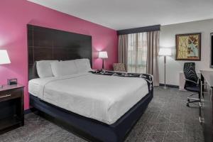 Un dormitorio con una cama grande y una pared rosa en La Quinta by Wyndham Dallas I-35 Walnut Hill Ln, en Dallas 60 fotos más