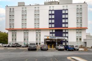 a large white building with cars parked in a parking lot at Comfort Inn & Suites Alexandria West in Alexandria