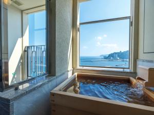 a bath tub with a view of the ocean at La Vista Atami Terrace in Atami