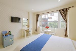 a bedroom with a blue and white bed and a window at Thanh Downtown Hotel - Bước Chân Là Đến Chợ Đêm in Da Lat