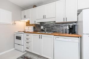 Una cocina blanca con gabinetes blancos y un fregadero. en Alpine Cove - Condo in Collingwood - Sleeps 6, en Collingwood 13 fotos más