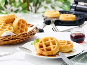 東近江市にあるコンフォートイン八日市のシロップをかけたワッフルのプレートとワッフルのバスケット