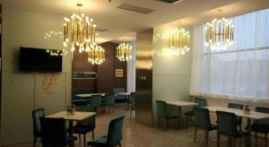 uma sala de jantar com mesas, cadeiras e lustres em Jinjiang Inn Style Ningxia Guyuan Beijing Road em Guyuan