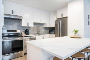 科灵伍德Cranberry Apres Nest Bright Reno Near Blue Mtn的厨房配有白色橱柜和白色台面