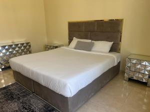 a bedroom with a large bed with white sheets and pillows at doge villa 3 in Dubai
