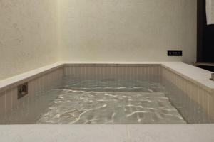 a bath room with a tub filled with water at Stay Passport Sapporo Ryokan Seoul Hongdae in Seoul