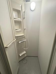 a small bathroom with an open refrigerator in a room at Aparthotel STATUS SUSUKINO 102 in Sapporo