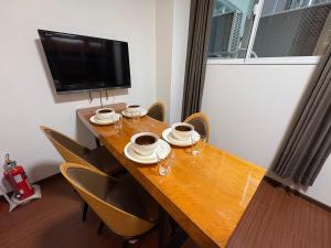 a dining room table with chairs and a television at Aparthotel STATUS SUSUKINO 102 in Sapporo