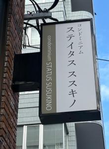 a sign hanging from the side of a building at Aparthotel STATUS SUSUKINO 102 in Sapporo