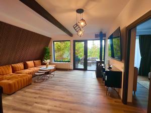 a living room with a couch and a table at Trei Mândre by Cabana CeiTrei in Cozăneşti