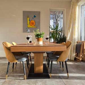 ein Esszimmer mit einem Holztisch und Stühlen in der Unterkunft Ma-Bebe PlayHouse with Private Sauna --- Lake, Parks and SPA Pools in 5 min in Pancharevo