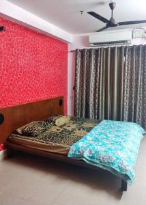 マンガロールにあるMohtisham Oasis Apartmentの赤い壁のベッドのある寝室