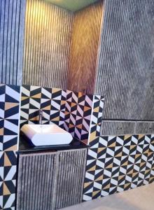 マンガロールにあるMohtisham Oasis Apartmentのモザイクの壁のバスルーム(シンク付)