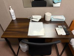 a desk in a hotel room with a phone at ドリームビレッジエンシン in Wada