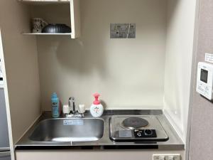 a small kitchen with a sink and a stove at ドリームビレッジエンシン in Kitakami