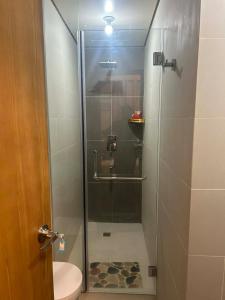 ein Badezimmer mit Glasdusche und WC in der Unterkunft Twinlakes Tagaytay Vinesera Manor1 3F in Balibaguhan