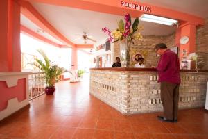 a man standing at the counter of a restaurant at Habitation Hatt Hotel in Delmas