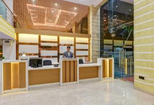 a man standing at a counter in a building at Hotel Ambience in New Delhi