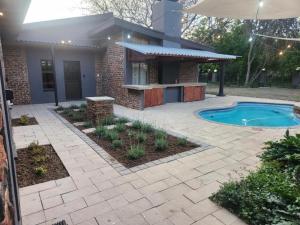 a backyard with a swimming pool and a house at 24 on Fuschia in Welkom