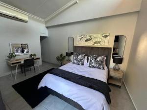 韦尔科姆24 on Fuschia的一间卧室配有一张大床、一张桌子和一张书桌