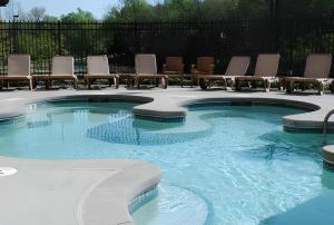 a swimming pool with lounge chairs and chairs in it at Adam's Mark Hotel & Conference Center in Independence