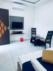a living room with a tv and a couch and a table at RKM Pearl in Cochin