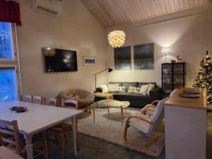 a living room with a couch and a christmas tree at Villa Ateljee in Rovaniemi