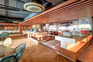 a restaurant with wooden tables and chairs in a room at Sunday Hotel Arshika Sunset Road in Kuta