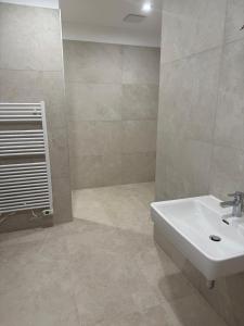 新锡德勒湖畔普巴赫Genuss Apartment的浴室配有白色水槽和瓷砖地板。