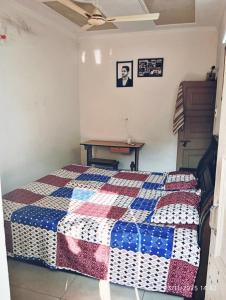 a bedroom with a quilt on a bed at Peaceful Park-View 2BHK Apartment With Balcony - On Kalka-Simla Highway in Kālka +3 photos