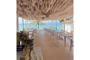 a restaurant with tables and chairs and the ocean at Aya Beach Resort Koh Lipe in Ko Lipe