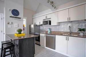 eine Küche mit weißen Schränken und Geräten aus Edelstahl in der Unterkunft Stay A While Ski-In-Out Hot Tub & Shuttle in Blue Mountains