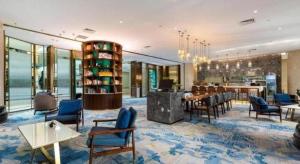 a lobby with chairs and tables and a dining room at Bliss International Hotel Weihai in Weihai