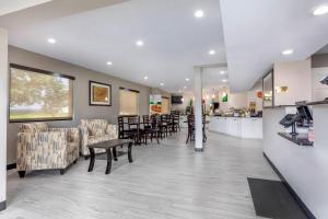 a waiting room with tables and chairs and a counter at Quality Inn McComb in McComb
