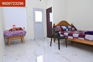 a bedroom with two beds and a table and chairs at Gugan home stay in Tiruchchendūr