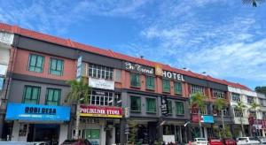 a building on a street with cars parked in front of it at In Trend Hotel in Kampong Nipah Panjang