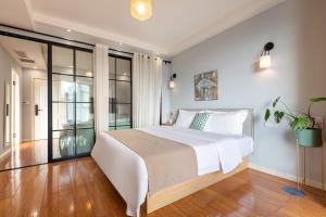 a bedroom with a large white bed and glass walls at Guyu B&B in Chongqing