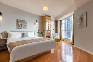 a bedroom with a large bed and a large window at Guyu B&B in Chongqing