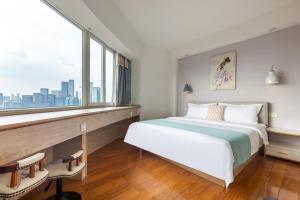 a bedroom with a large bed and a large window at Guyu B&B in Chongqing