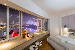 a bedroom with a large window with a view of the city at Guyu B&B in Chongqing +283 photos