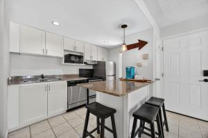 a kitchen with white cabinets and a counter with stools at Heavenly Hideaway Ski-In-Out Pool Shuttle in Blue Mountains