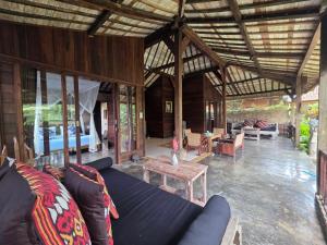 una sala de estar con un sofá azul en una casa en Tano Home Villas, en Ubud