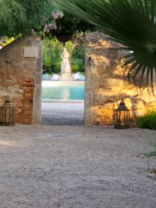 Un jardín con una fuente y una estatua al fondo. en Pilates Nosara, en Playa Guiones