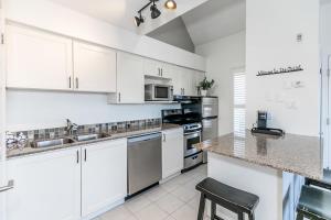 een keuken met witte kasten en een aanrechtblad bij Mountain Peaks Ski-In-Out Pool Shuttle in Blue Mountains