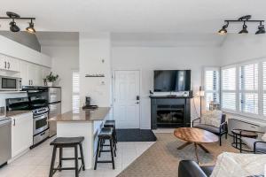 een keuken met witte kasten en een tafel en stoelen bij Mountain Peaks Ski-In-Out Pool Shuttle in Blue Mountains