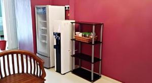 a black shelf next to a refrigerator in a room at HOTEL BAJET MUGHOH SENGOTI in Kampong Gong Kempas