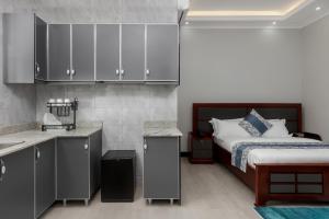 a bedroom with a bed and a kitchen with cabinets at Beal Mall & Hotel in Arua +27 photos