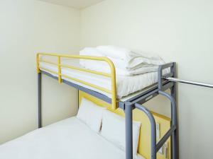 Litera con sábanas blancas encima en Comfort Inn Suwa Inter, en Suwa